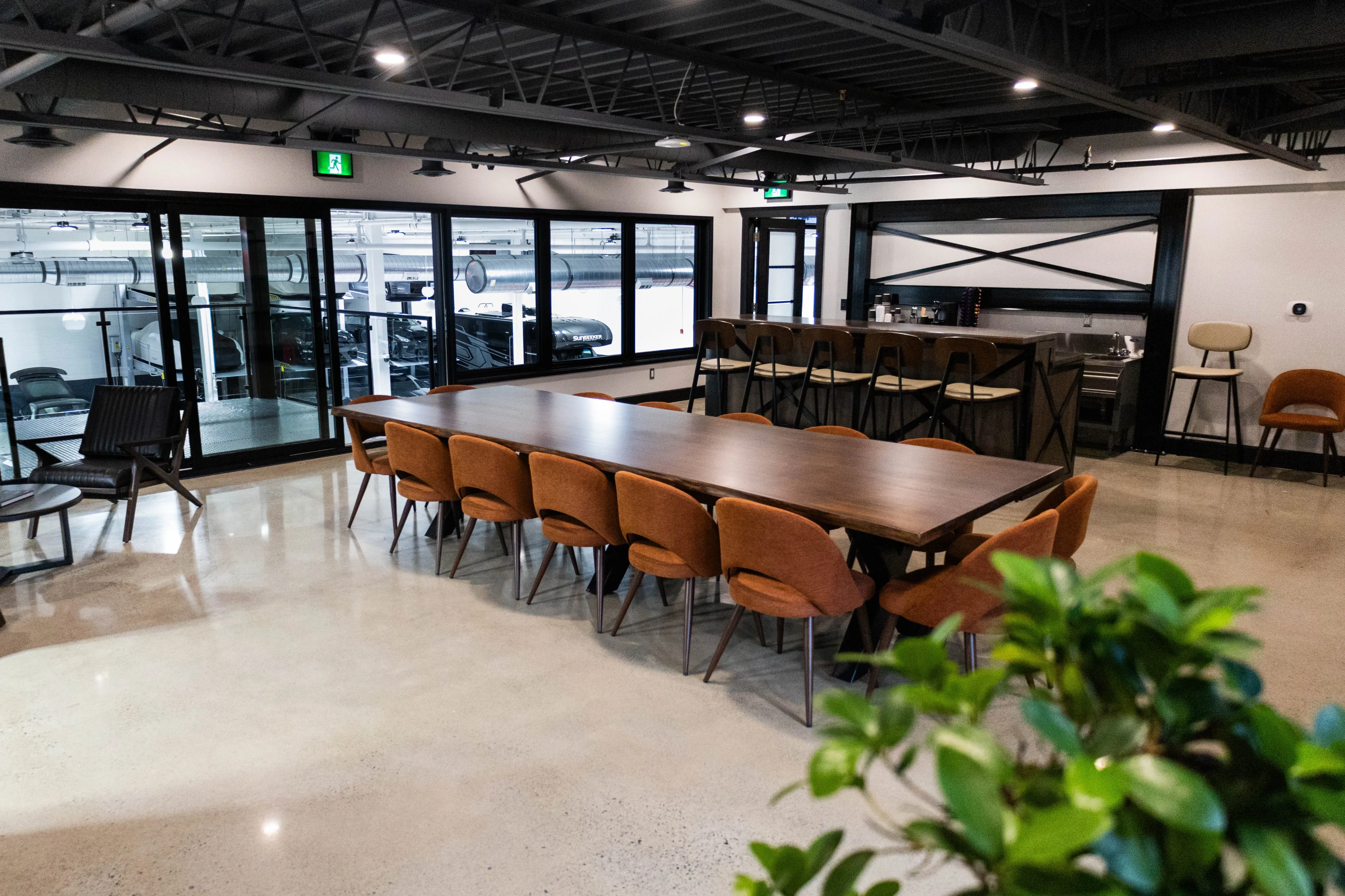 A boardroom with a coffee bar and windows showing off the vehicle storage area