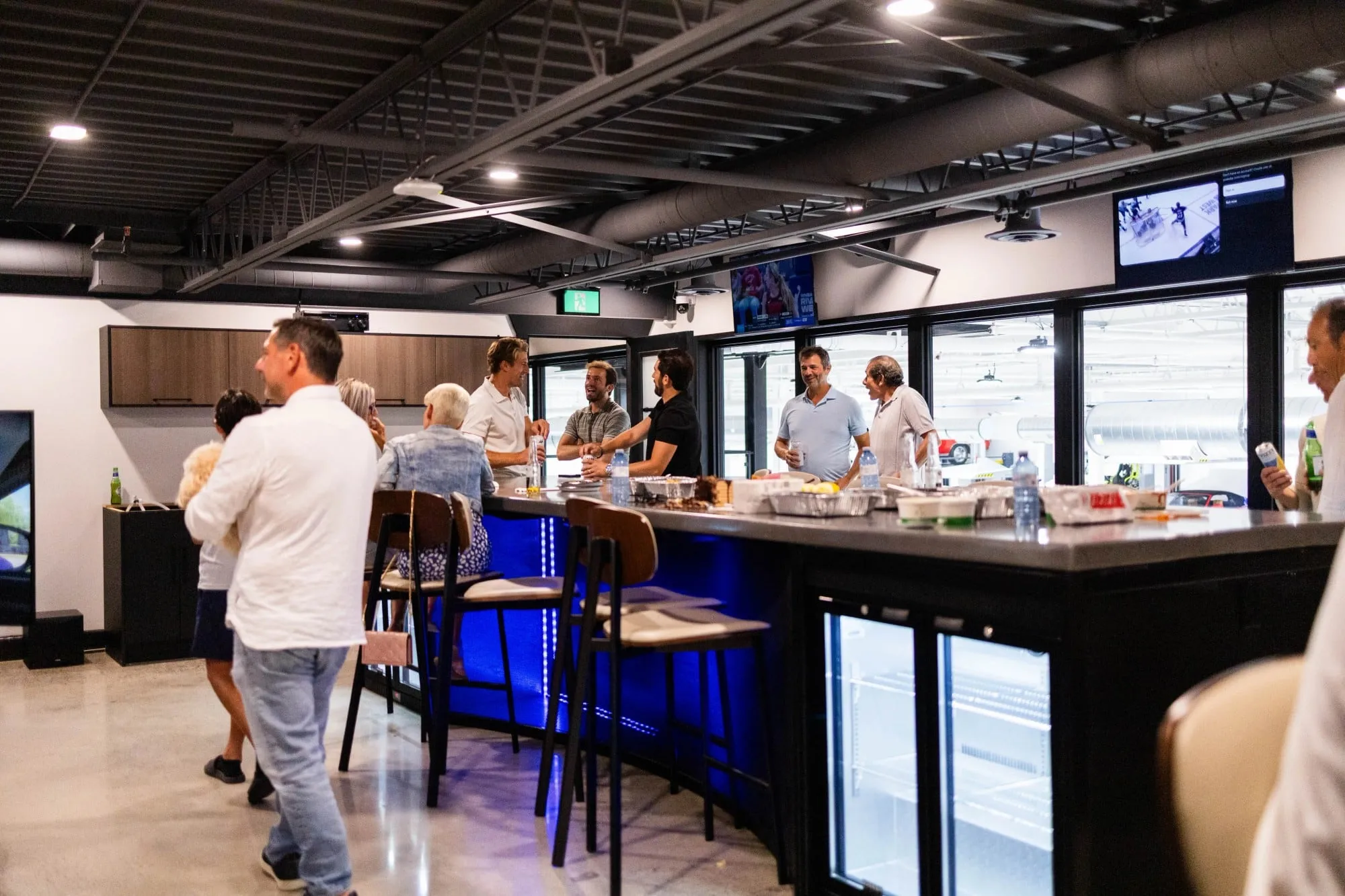A group of people standing around a bar
