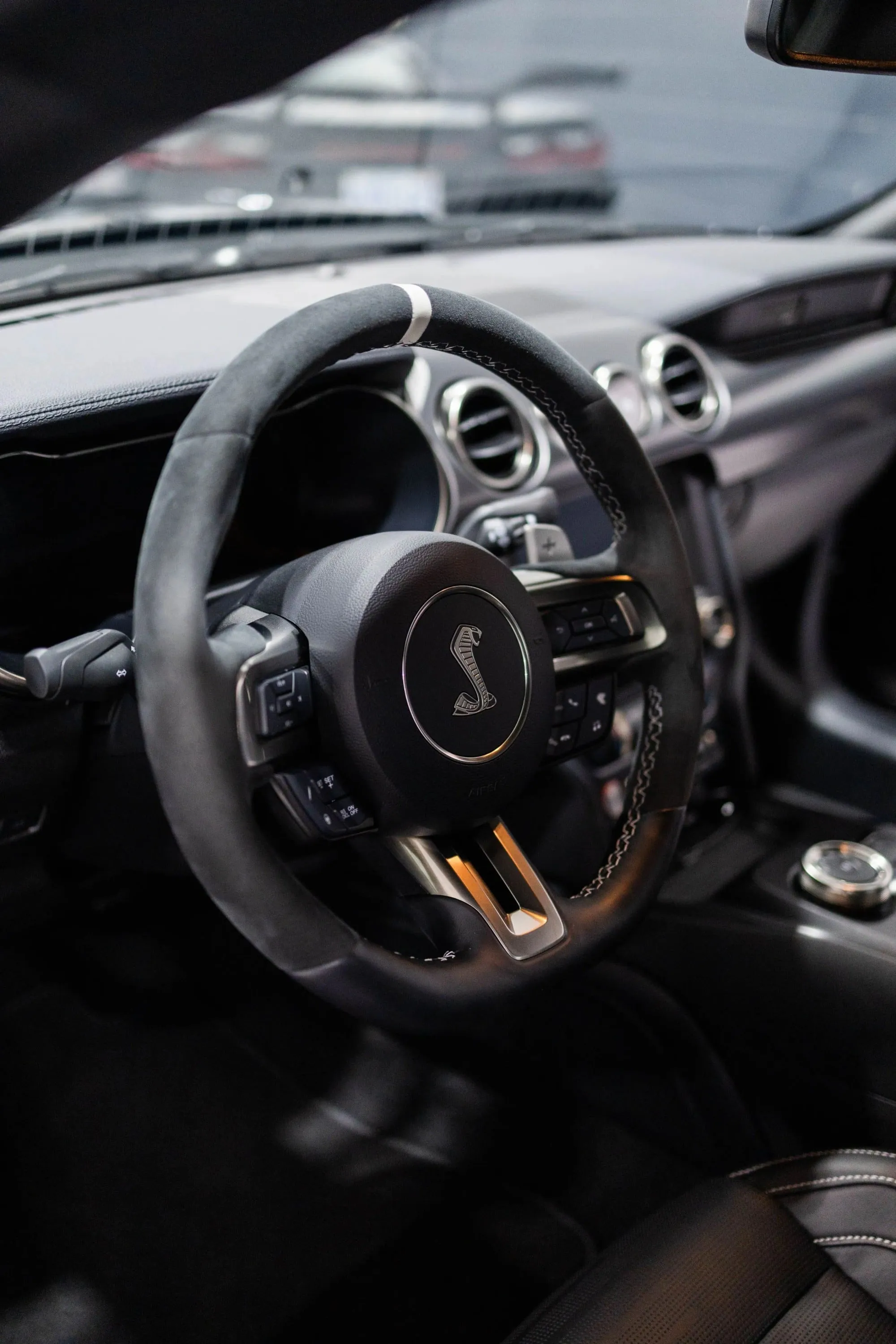 The interior of a car with a steering wheel and dashboard visible