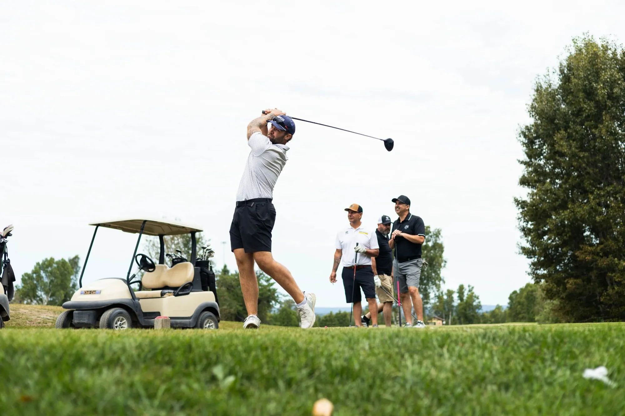 A group of people playing golf in the grass