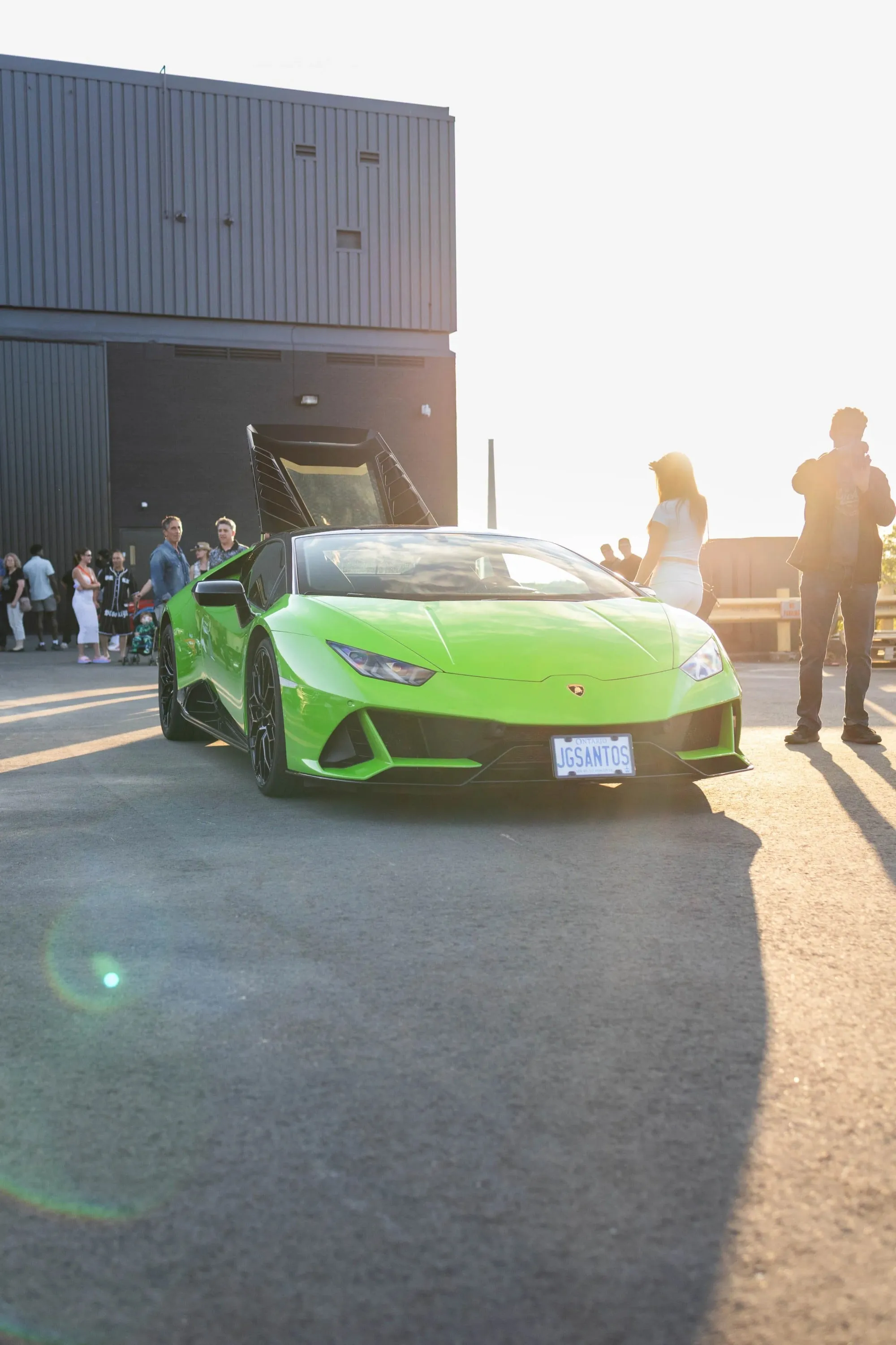 A green sports car parked in front of a building