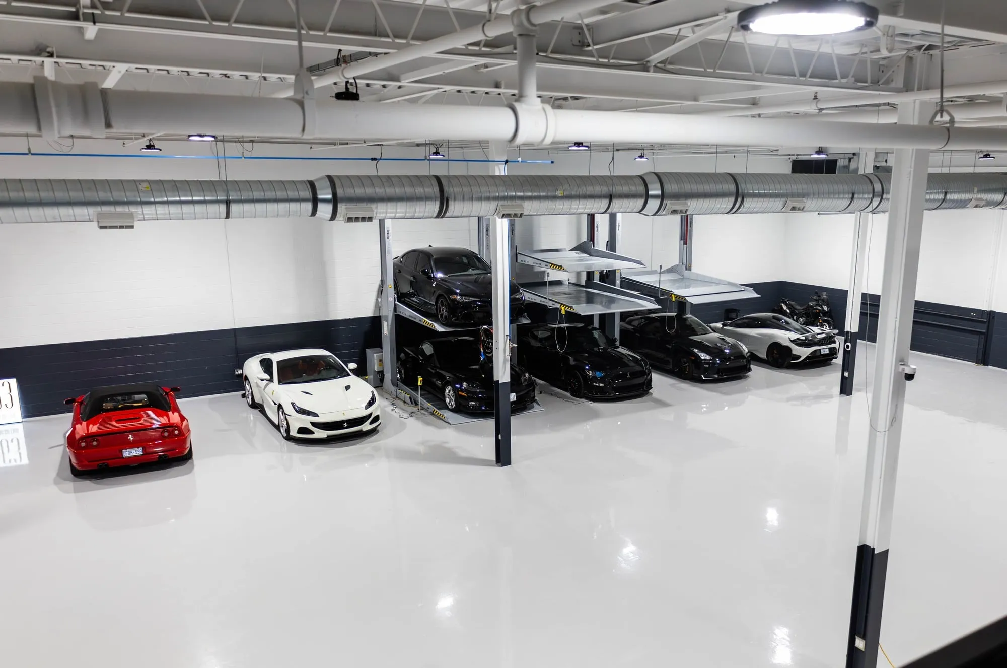 A garage with several cars parked in it