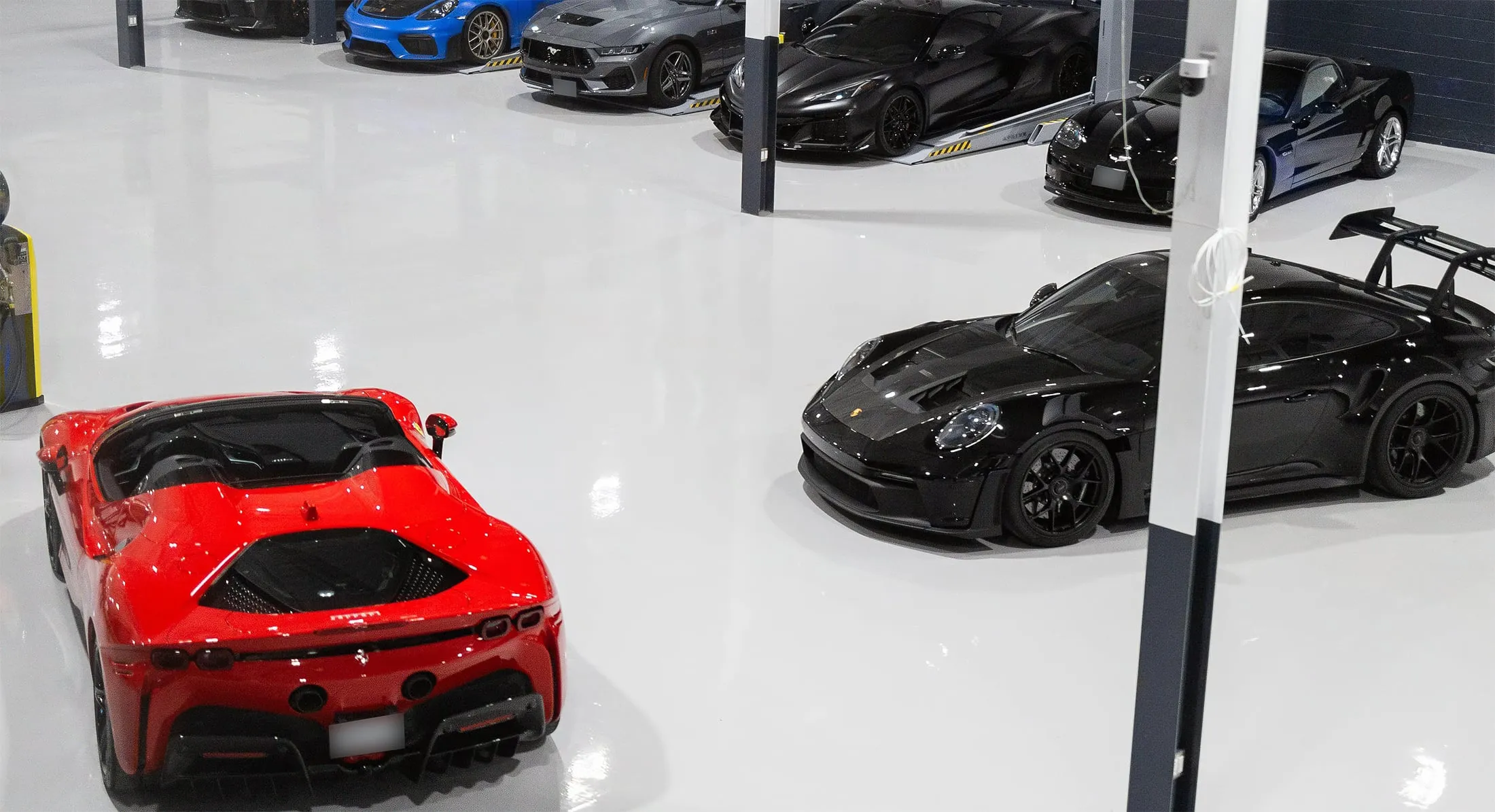 A brightly lit garage with lots of cars parked in it