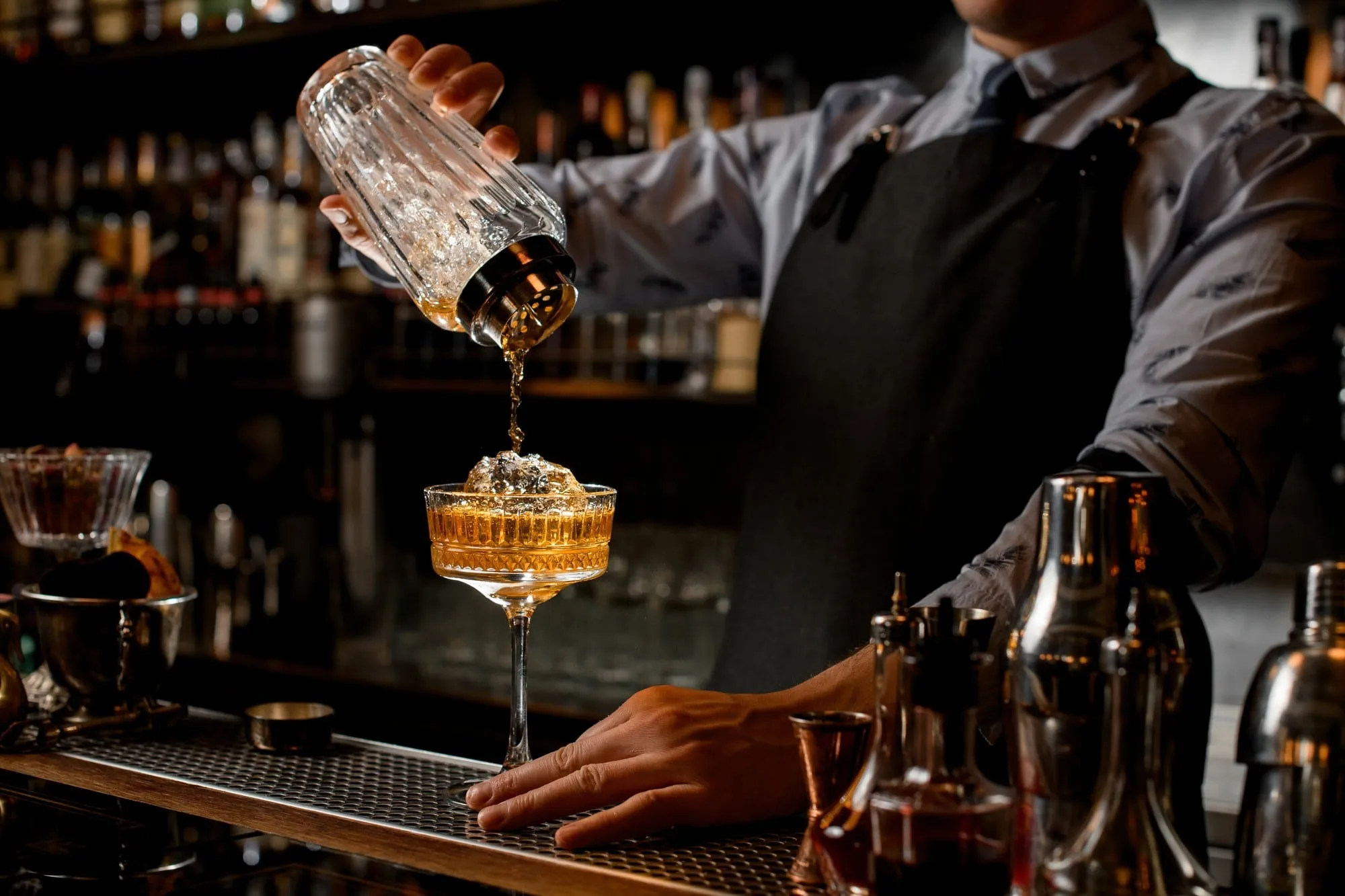 A bartender pouring a drink at a bar