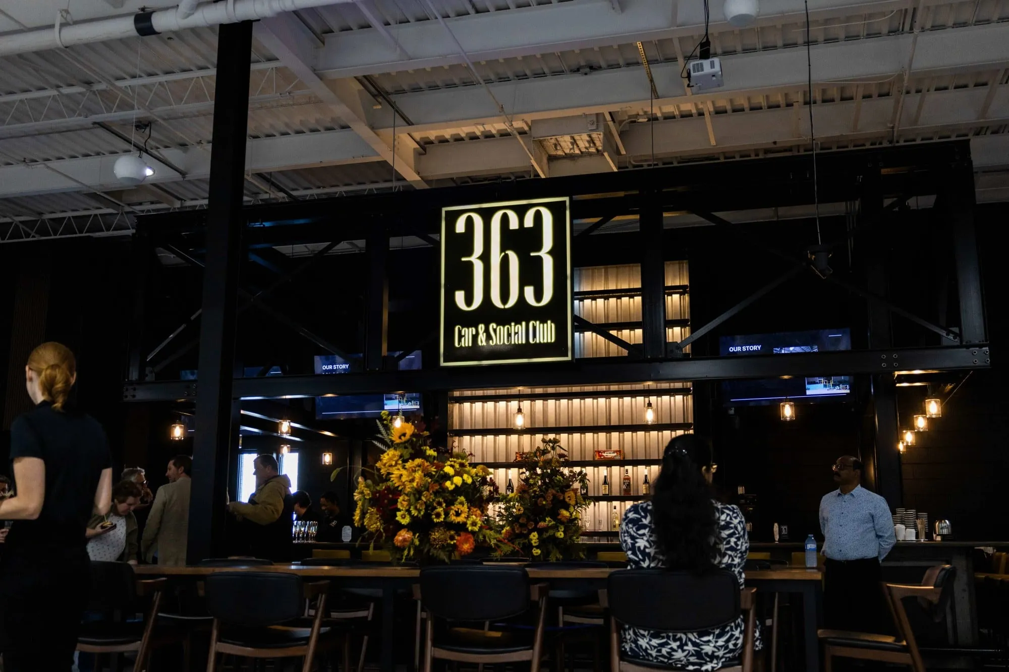 A group of people sitting at tables at a bar